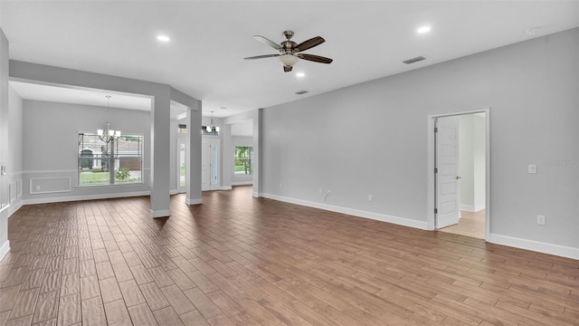 unfurnished living room with ceiling fan with notable chandelier, wood finished floors, visible vents, and recessed lighting