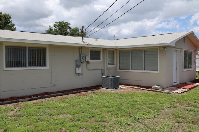 view of side of home with a yard and central AC unit