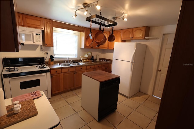 kitchen featuring a kitchen island, sink, wooden counters, light tile patterned floors, and white appliances