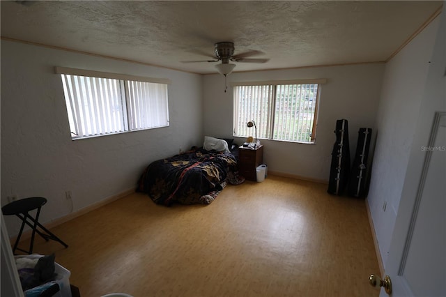 bedroom featuring a textured ceiling, ceiling fan, and light hardwood / wood-style flooring