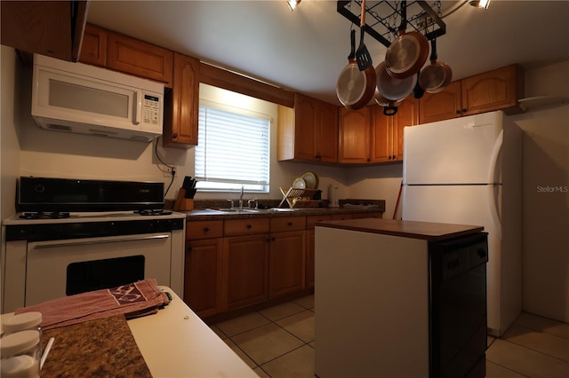 kitchen with light tile patterned flooring, white appliances, and sink