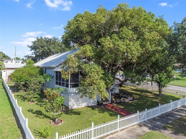 view of front of house featuring a sunroom and a front yard