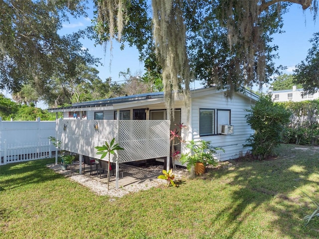 back of property featuring cooling unit, a lawn, and a wooden deck