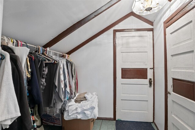 spacious closet with lofted ceiling and a chandelier