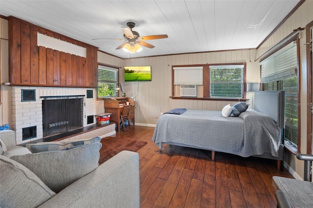 bedroom featuring ceiling fan, ornamental molding, a brick fireplace, and hardwood / wood-style floors