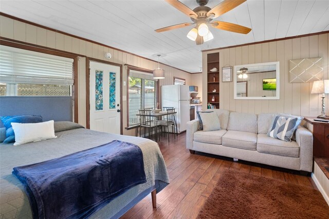 bedroom with dark wood-type flooring, ornamental molding, ceiling fan, and white refrigerator