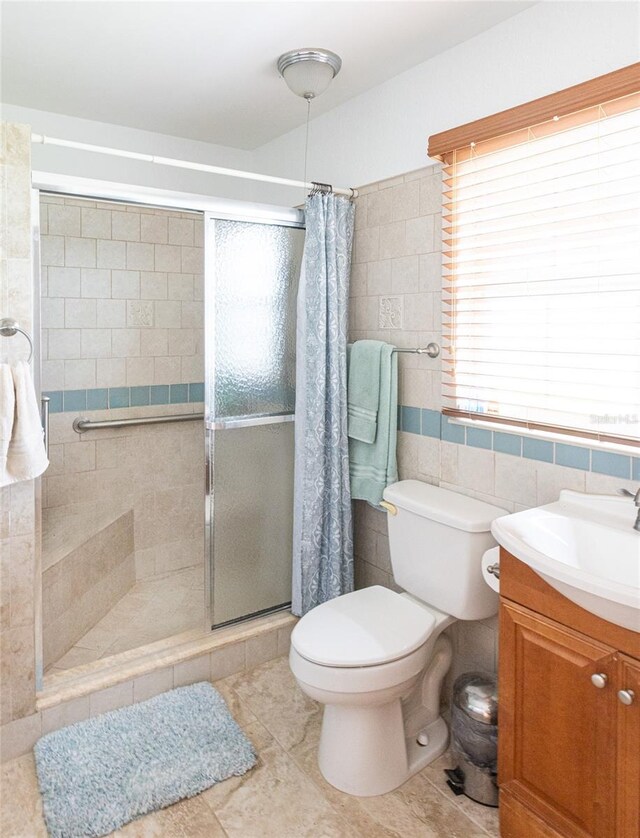 bathroom featuring vanity, tile walls, curtained shower, and toilet