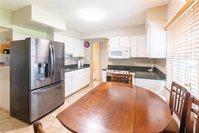 kitchen with tasteful backsplash, appliances with stainless steel finishes, white cabinetry, light tile patterned flooring, and sink