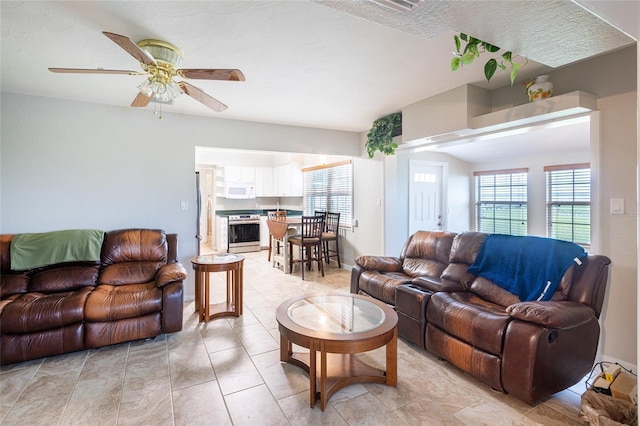 tiled living room with ceiling fan