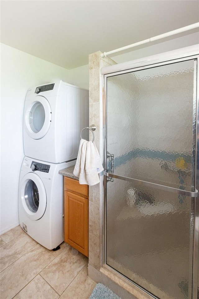 clothes washing area with stacked washer / dryer and light tile patterned flooring