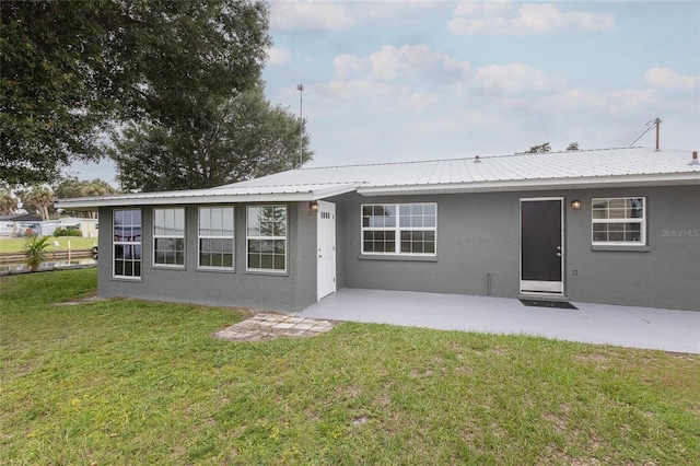 rear view of property featuring a patio area and a lawn