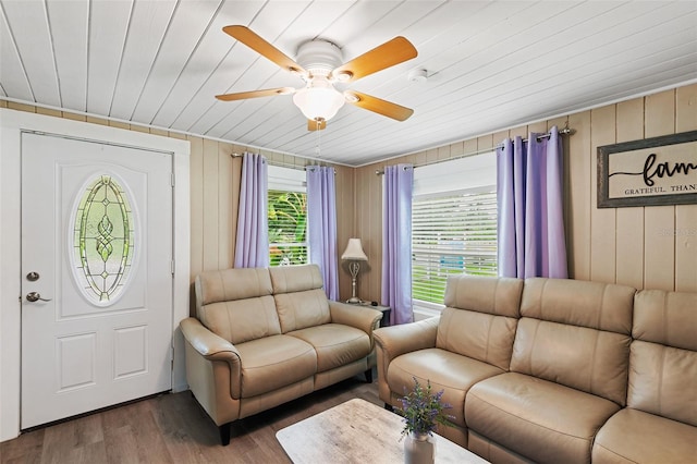 living room featuring ceiling fan, wood-type flooring, and wooden ceiling