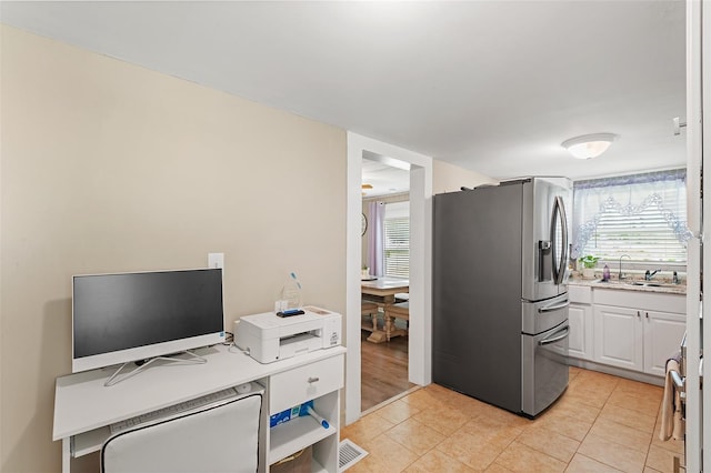 interior space with light tile patterned flooring, sink, and a wealth of natural light