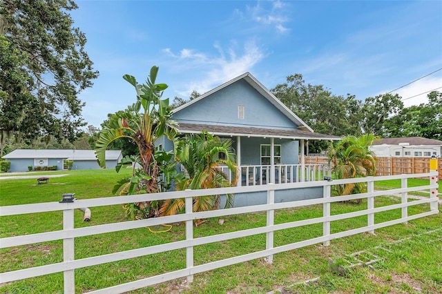 view of side of home with a porch and a yard