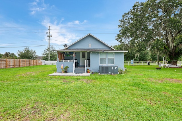 rear view of house with a yard and central AC