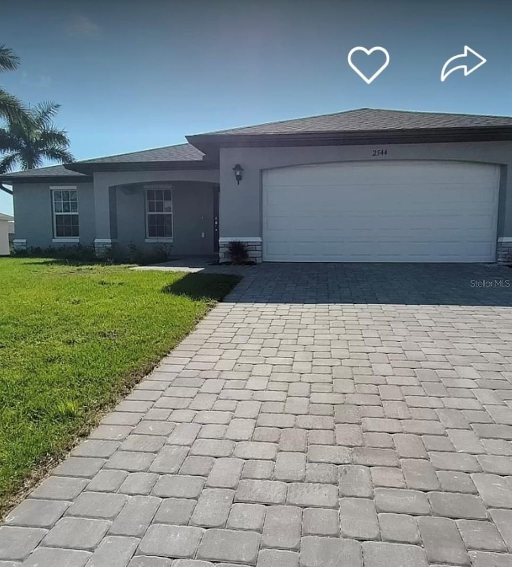 single story home featuring a garage and a front yard