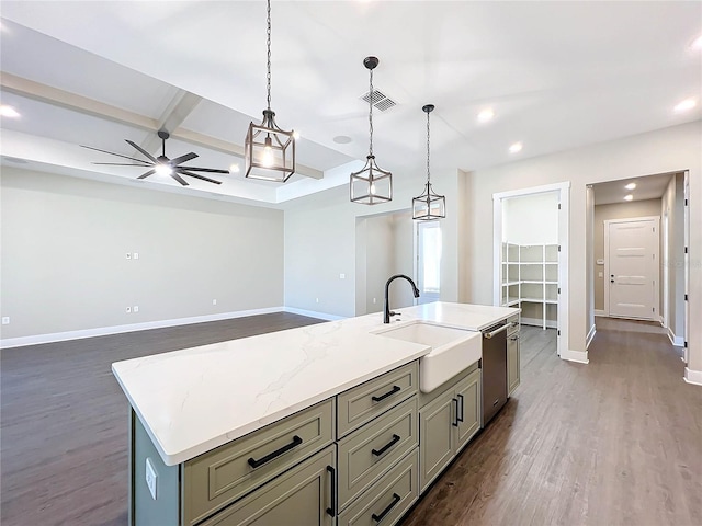 kitchen featuring light stone counters, sink, a center island with sink, dark hardwood / wood-style floors, and hanging light fixtures