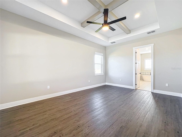 empty room with beam ceiling, dark hardwood / wood-style flooring, a tray ceiling, and ceiling fan