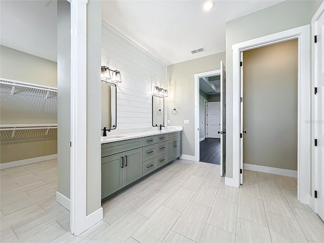 bathroom featuring vanity and wooden walls