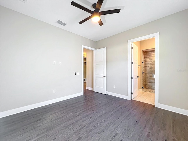 unfurnished bedroom featuring ceiling fan, dark wood-type flooring, and ensuite bath