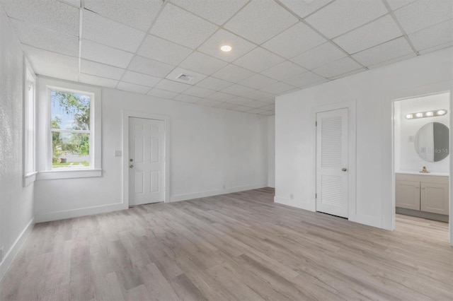 interior space with sink, a paneled ceiling, and light hardwood / wood-style floors