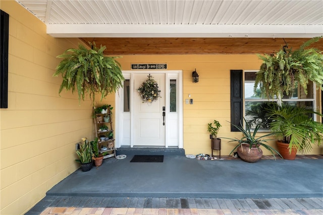 view of exterior entry featuring covered porch