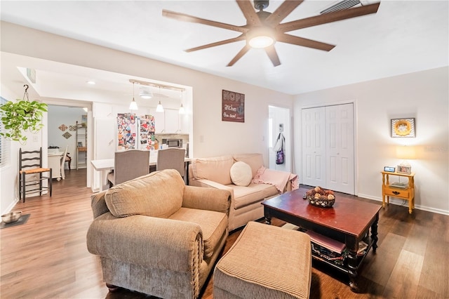 living room featuring ceiling fan and hardwood / wood-style flooring