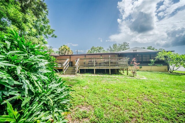 back of house with a deck and a yard