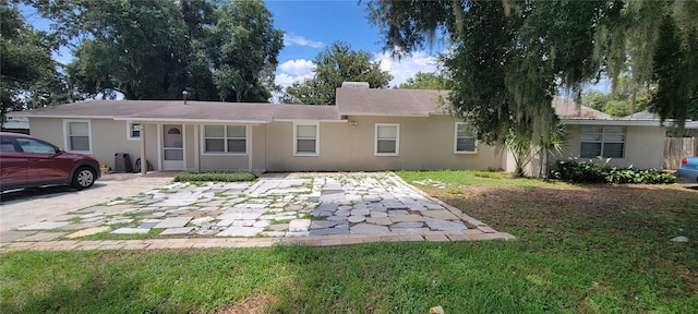 ranch-style home featuring a front yard and stucco siding