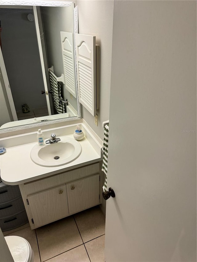 bathroom featuring tile patterned flooring, vanity, and toilet