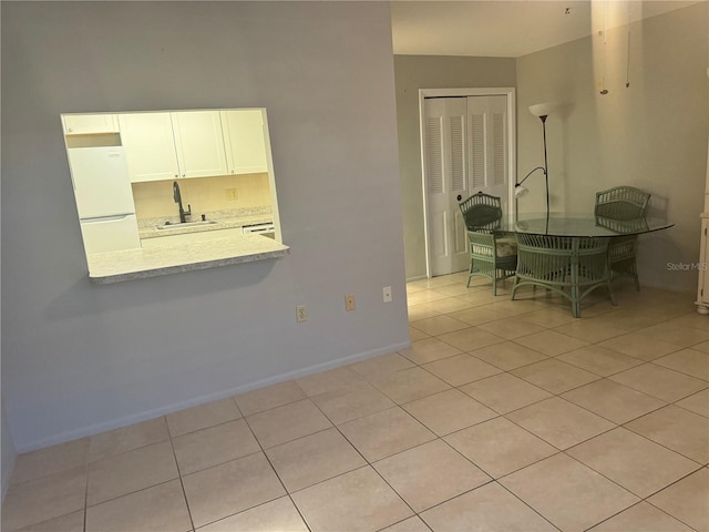 unfurnished dining area featuring sink and light tile patterned floors