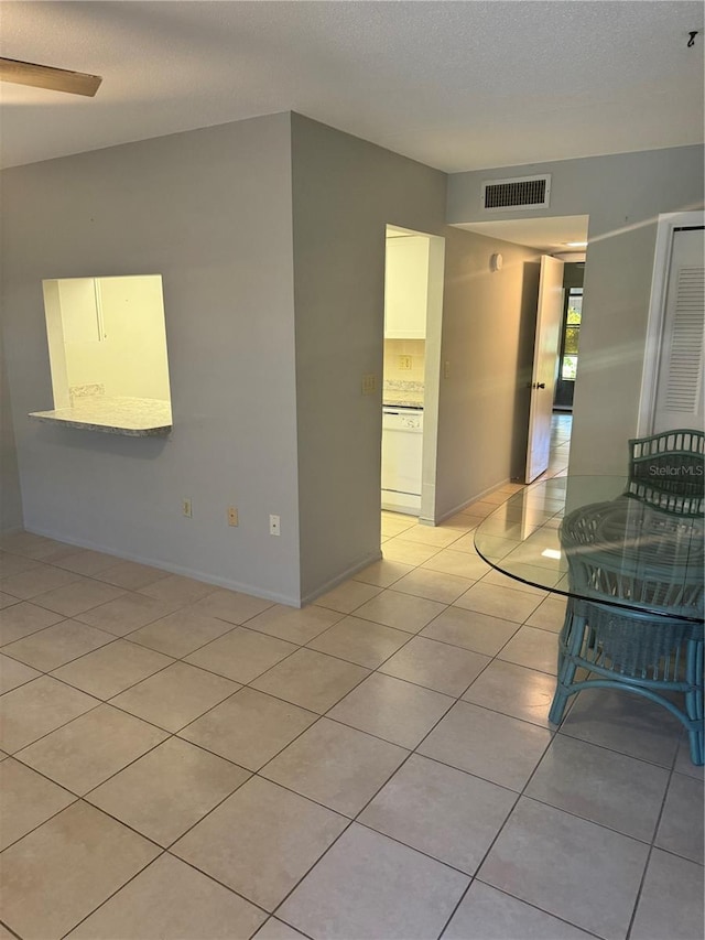 tiled empty room with a textured ceiling