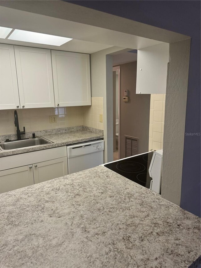 kitchen featuring tasteful backsplash, white cabinetry, sink, and white appliances