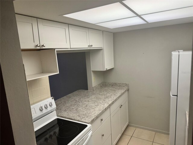 kitchen featuring light tile patterned floors, white appliances, white cabinetry, backsplash, and light stone countertops