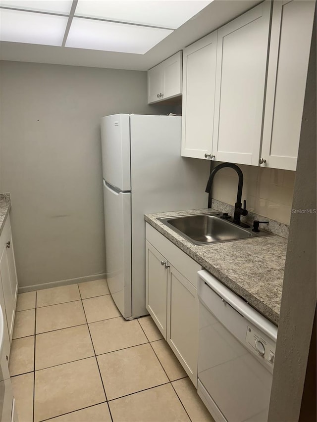 kitchen with white cabinetry, light tile patterned flooring, dishwasher, and sink