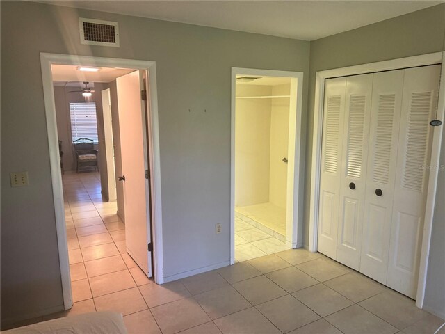 unfurnished bedroom with light tile patterned floors and a closet