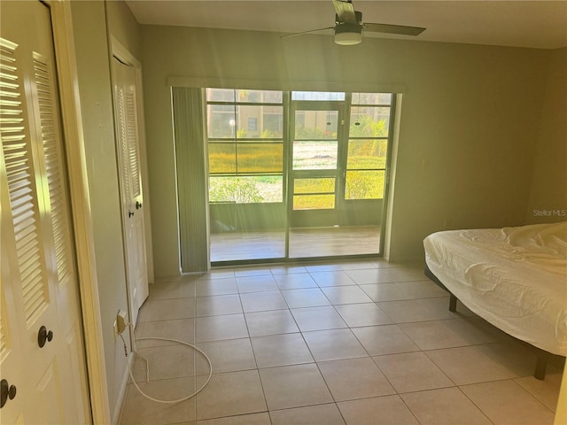 bedroom with multiple windows, light tile patterned floors, and ceiling fan