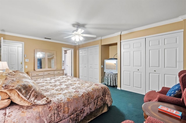 carpeted bedroom with ceiling fan, crown molding, and two closets