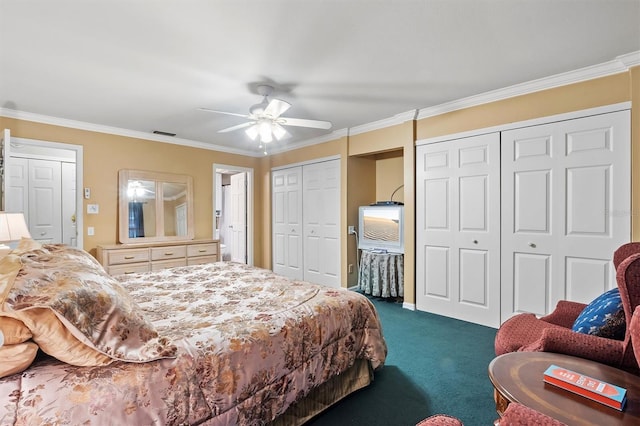 bedroom with crown molding, dark colored carpet, visible vents, and multiple closets