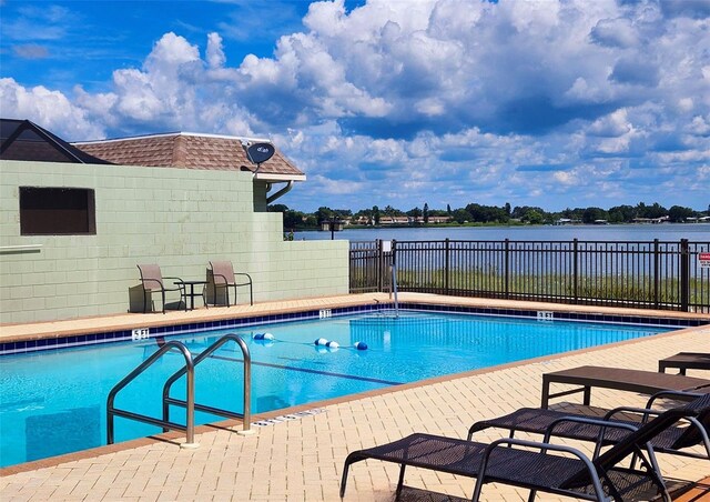 view of swimming pool with a water view and a patio