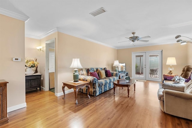 living room featuring crown molding, french doors, ceiling fan, and light wood-type flooring