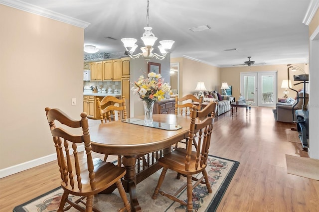 dining room with ceiling fan with notable chandelier, light wood-type flooring, and crown molding