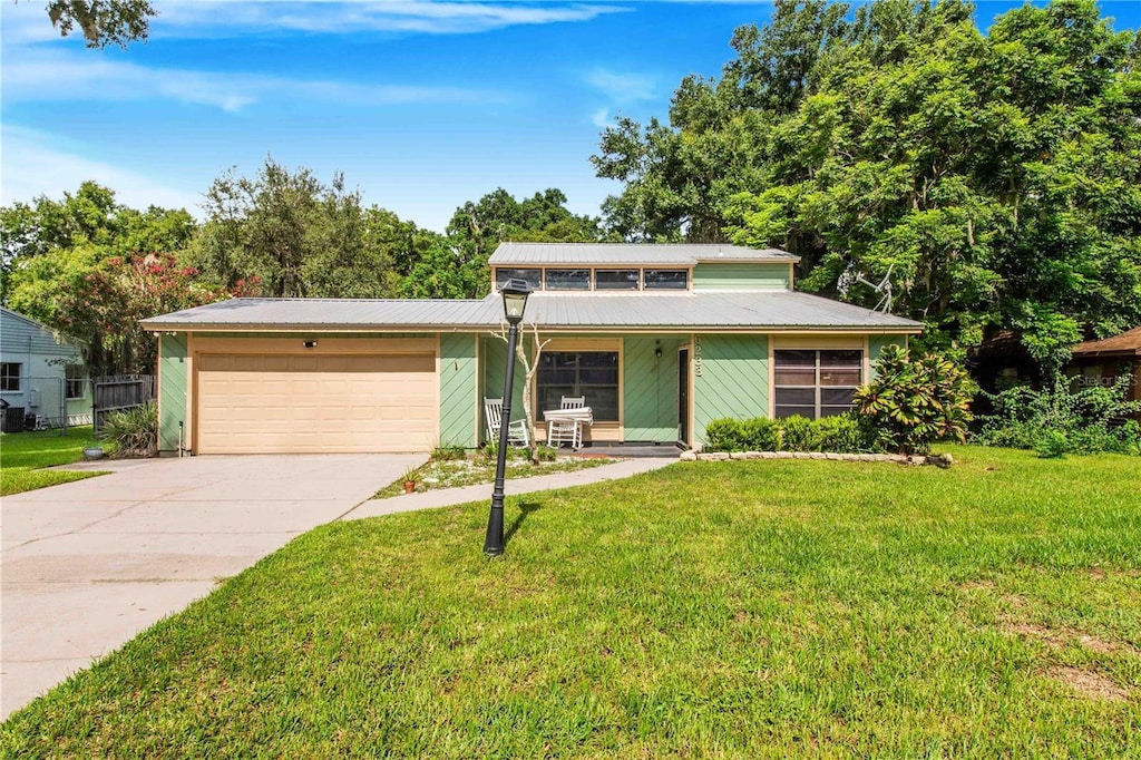 view of front of house featuring a garage, a front yard, and covered porch