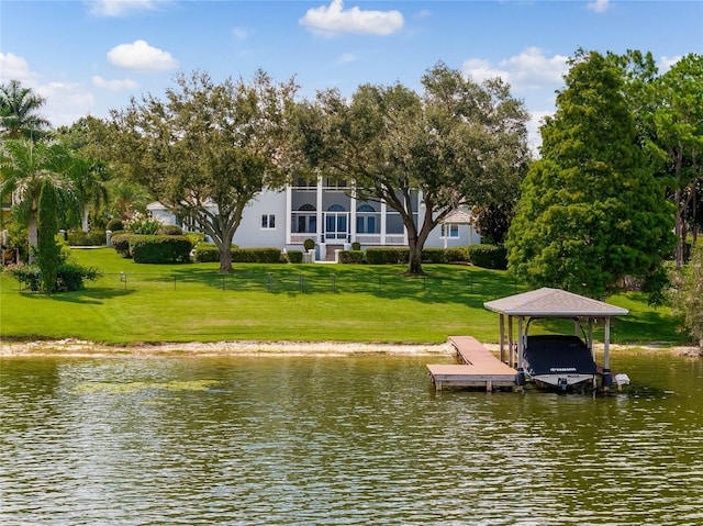 view of dock featuring a yard, a water view, boat lift, and fence