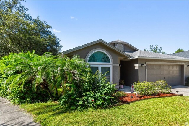 view of front of home with a front yard and a garage