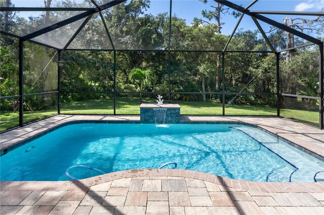 view of swimming pool with a yard, pool water feature, glass enclosure, and a patio area