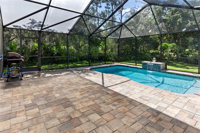 view of swimming pool with a lanai, a grill, pool water feature, and a patio