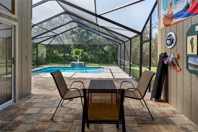 view of patio / terrace with pool water feature, a swimming pool with hot tub, and a lanai