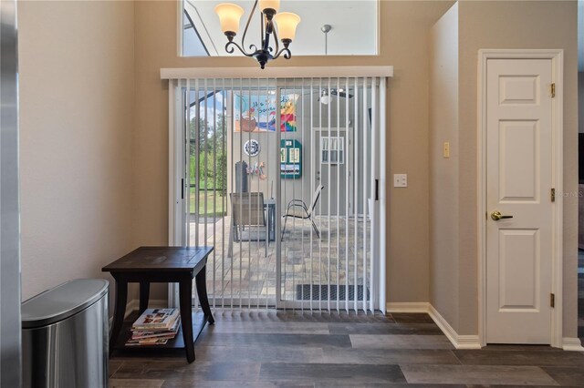 entryway featuring dark hardwood / wood-style flooring and an inviting chandelier