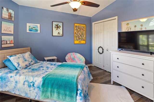 bedroom with vaulted ceiling, ceiling fan, a closet, and dark hardwood / wood-style floors